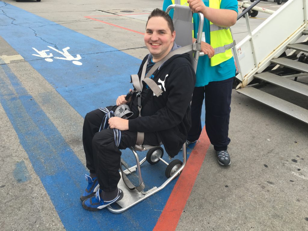 Rudy sur un fauteuil de transfert à l'aéroport de Berlin en 2016